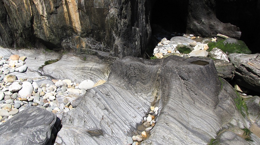 geschliffene Steine, hier schleift die Brandung mit kleinen Steinen die Felsen