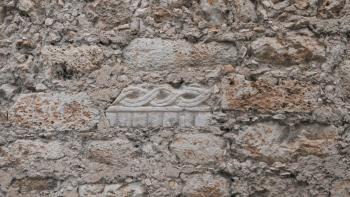 Wand der Kathedrale mit altem Mayarelikt links neben dem Fenster; zum Bau wurden Mayatempel abgerissen und wiederverwendet.
