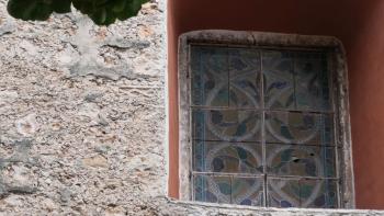 Wand der Kathedrale mit altem Mayarelikt links neben dem Fenster; zum Bau wurden Mayatempel abgerissen und wiederverwendet.