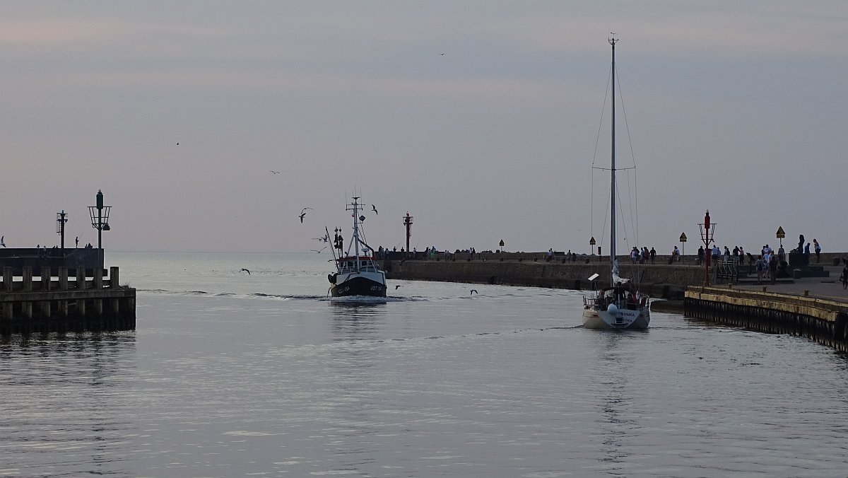 Fischkutter passiert Hafeneinfahrt