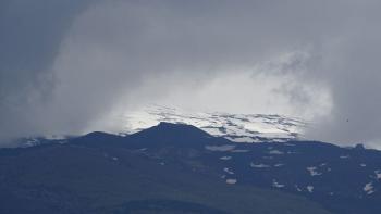 der wolkenverhangene Ätna gibt kurz seine Schneefelder frei