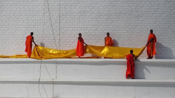 Mönche beim Abwickeln eines goldenen Seidenbandes, welches um die Stupa gewickelt war