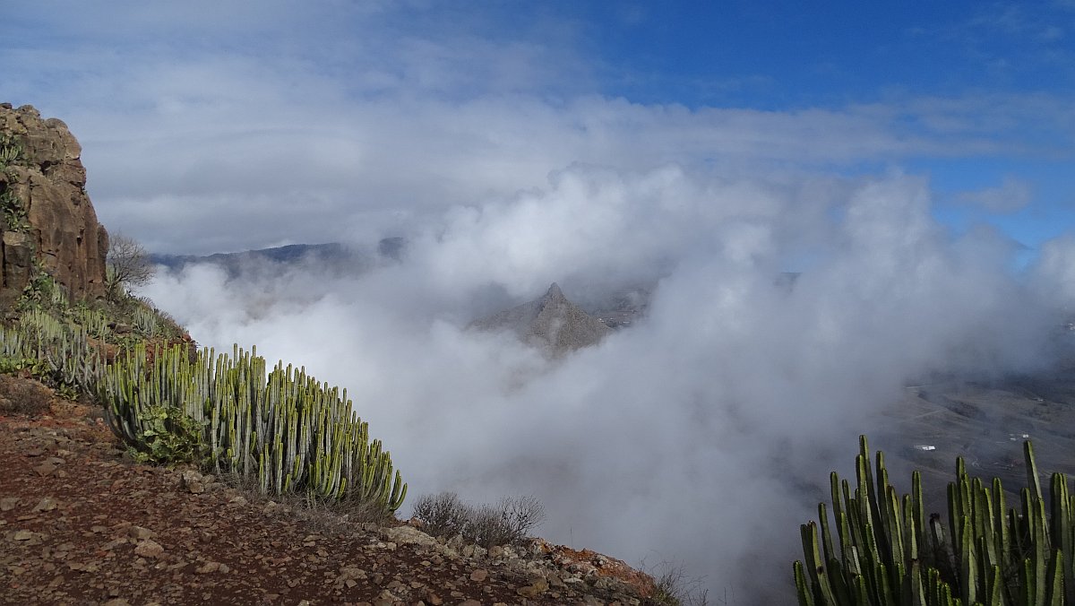 Wolken umwabern einen kleineren spitzen Gipfel, der mich an Lions Head in Kapstadt erinnert