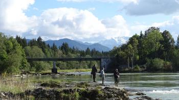 Angler am Lech, im Hintergrund die schneebedeckten Alpen